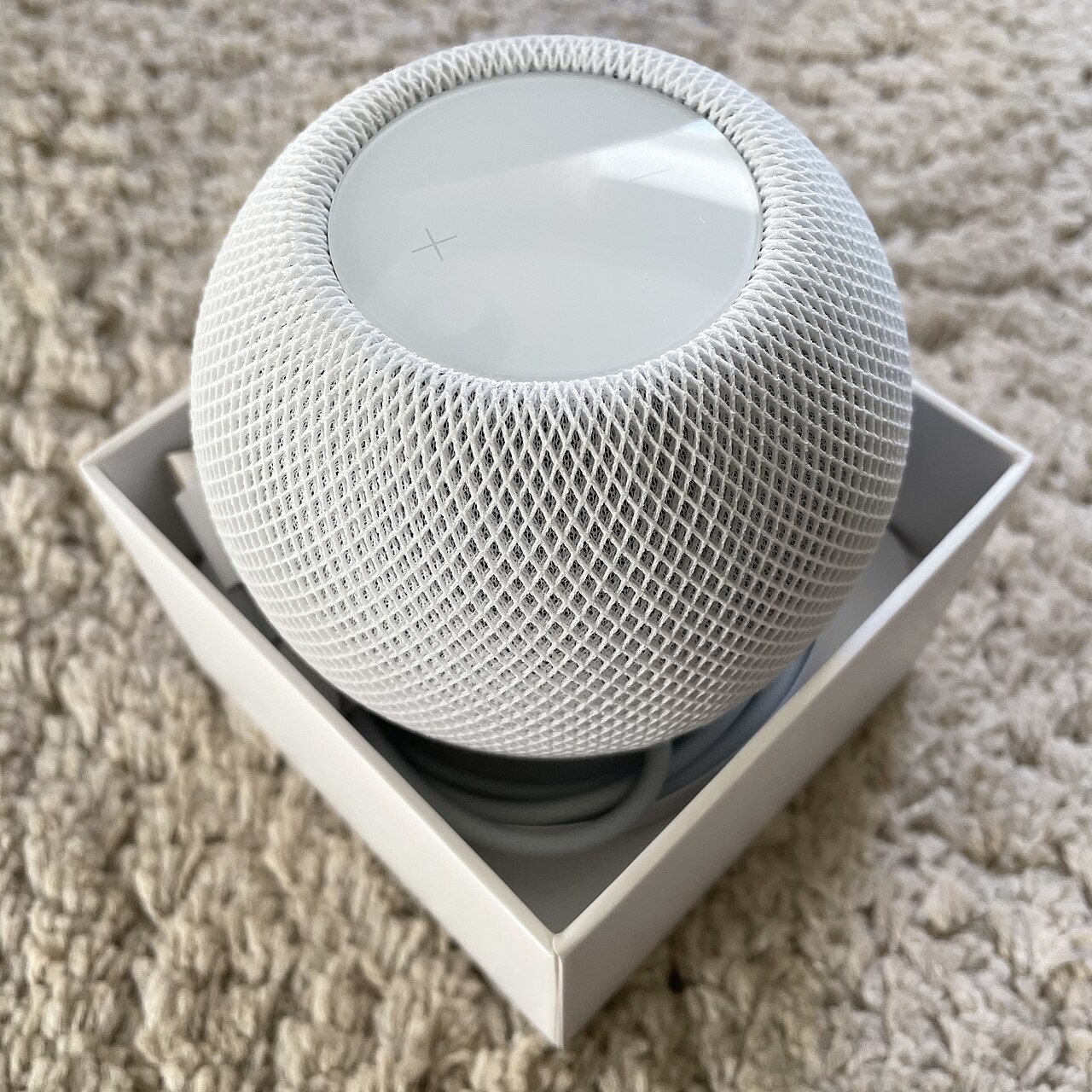 Белая умная колонка Apple HomePod mini 2 с сетчатым корпусом в фирменной коробке — иллюстрация к новости о старте продаж