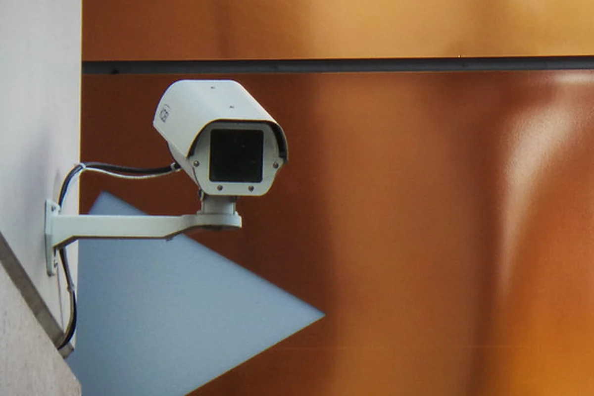 Цилиндрическая IP-камера в уличном корпусе, закреплённая на стене