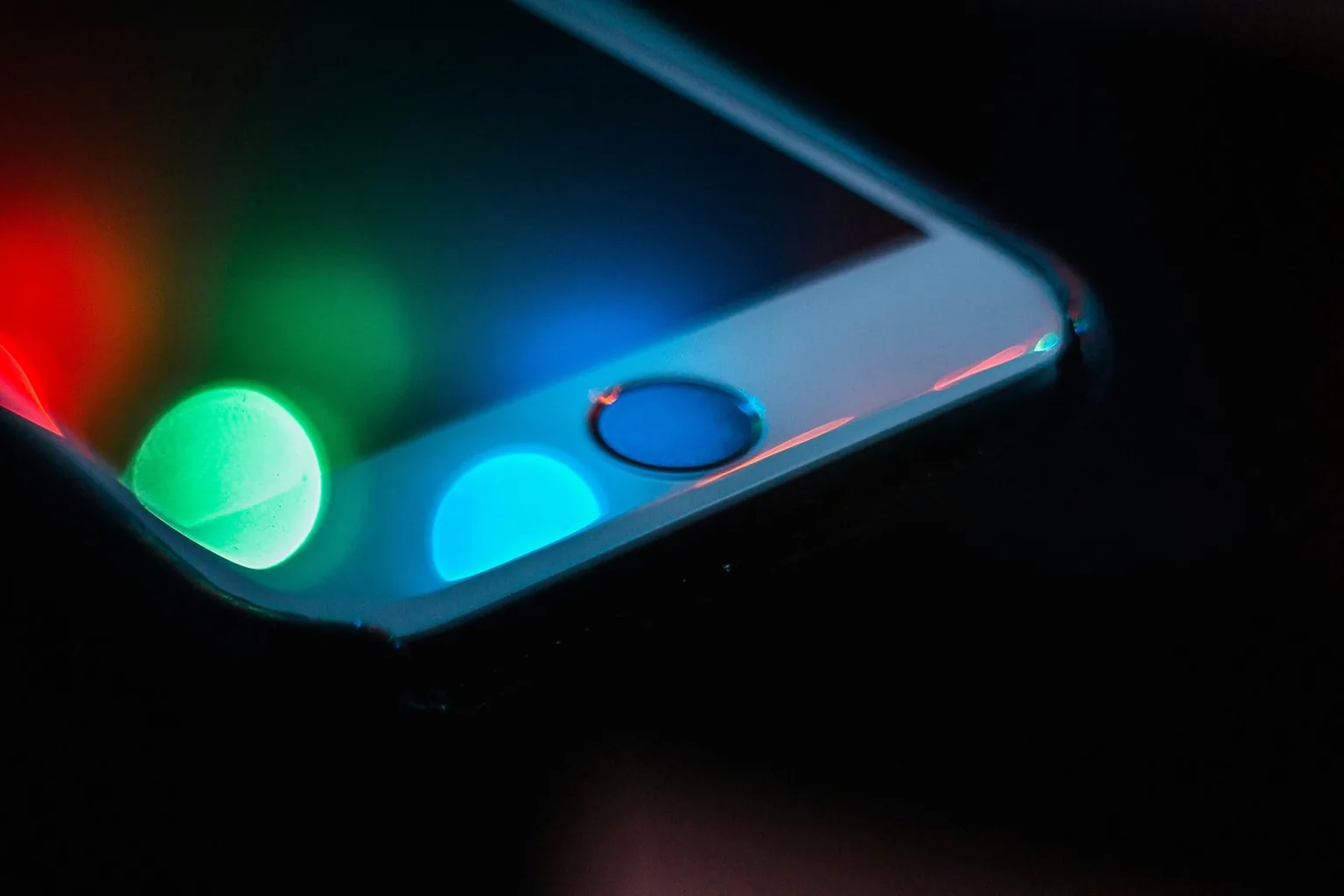 Крупный план смартфонного экрана с яркими RGB-пикселями OLED на тёмном фоне 2026