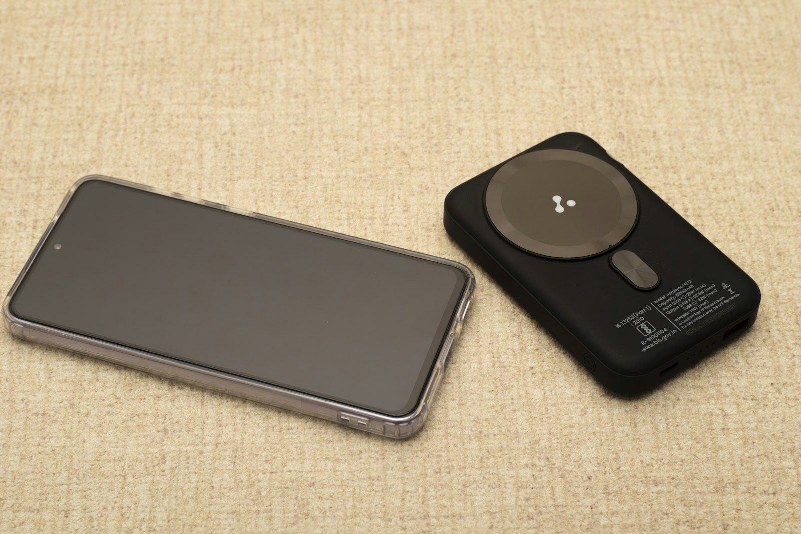 Смартфон и повербанк с USB-C рядом на текстильной поверхности — тематическая иллюстрация к новости о Vivo Y600 с батареей 10 000 мА·ч