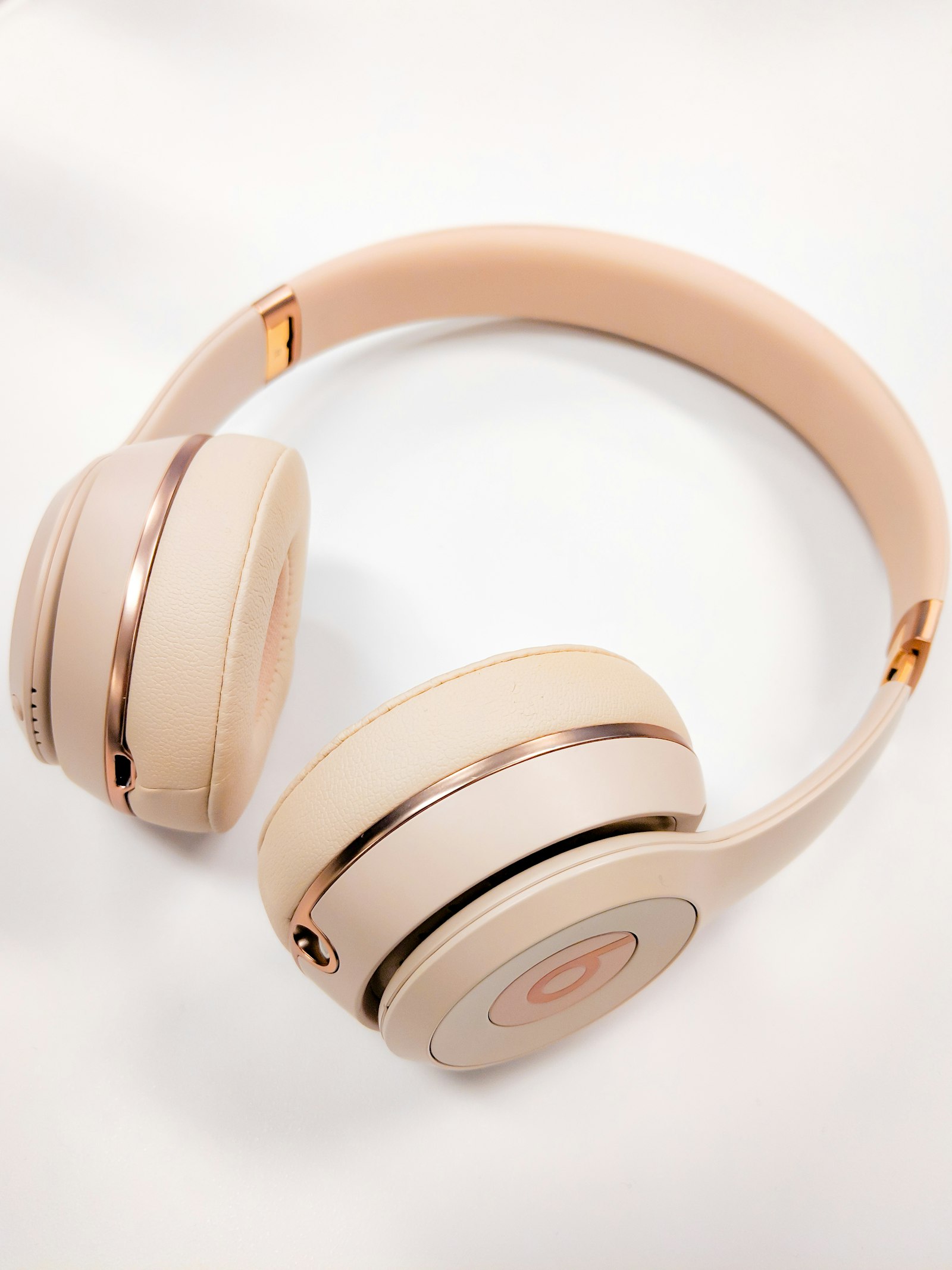 Накладные беспроводные наушники Beats в бежево-розовом цвете на белом фоне
