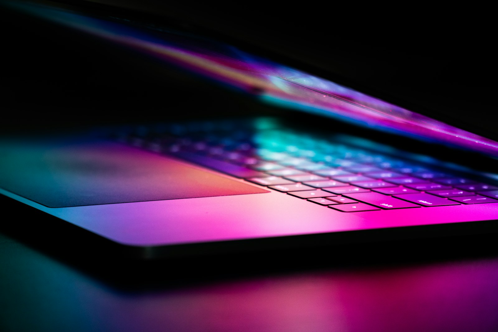 Тонкий ноутбук с подсвеченной AMOLED-панелью в полумраке
