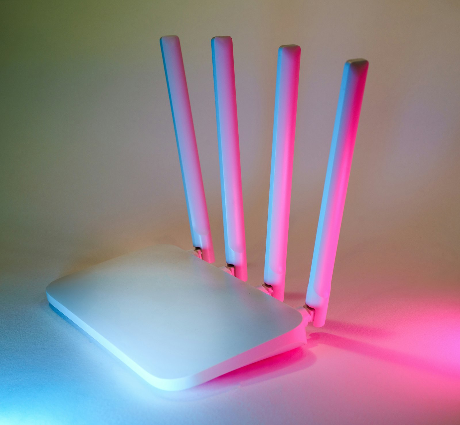 Wi-Fi роутер с четырьмя антеннами и цветной подсветкой на светлом столе